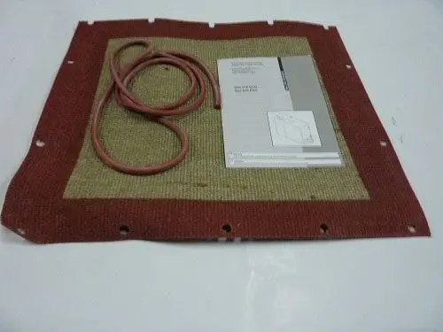 Isoliermaterial der Marke Remeha, bestehend aus einer rechteckigen Platte mit einer beige-rot gestreiften Oberfläche und einem roten Gummischlauch. Im Hintergrund eine technische Anleitung.